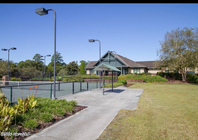 exterior space featuring tennis court and a lawn