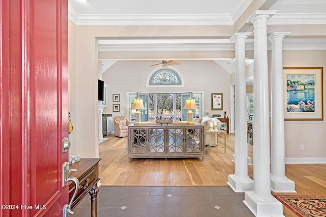 foyer featuring decorative columns, ornamental molding, and ceiling fan