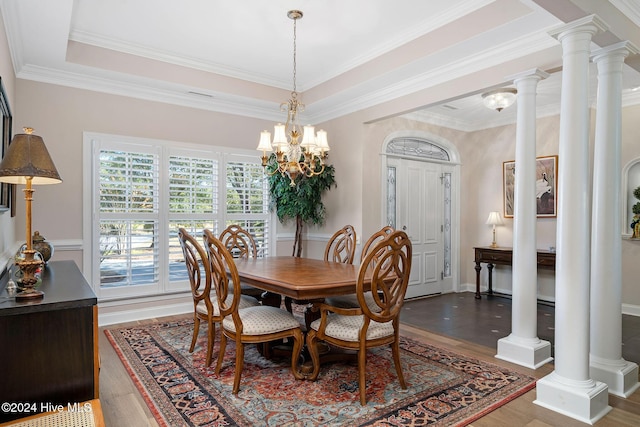 dining space featuring decorative columns, crown molding, and hardwood / wood-style floors