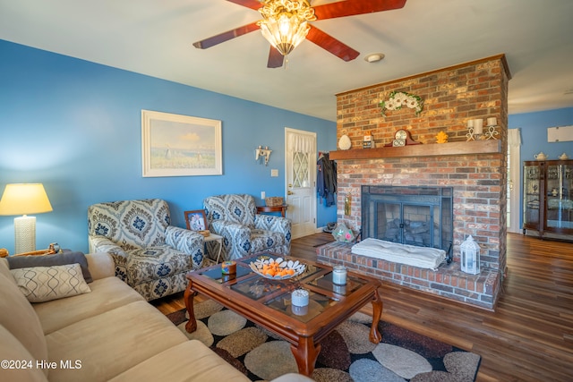 living room featuring a fireplace, ceiling fan, and dark wood-type flooring