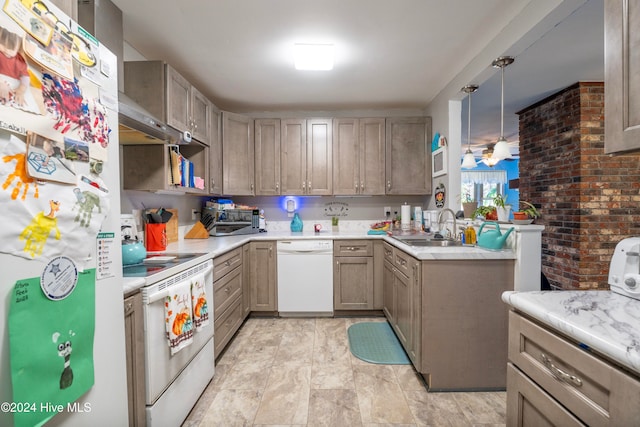 kitchen featuring white appliances, hanging light fixtures, kitchen peninsula, and sink