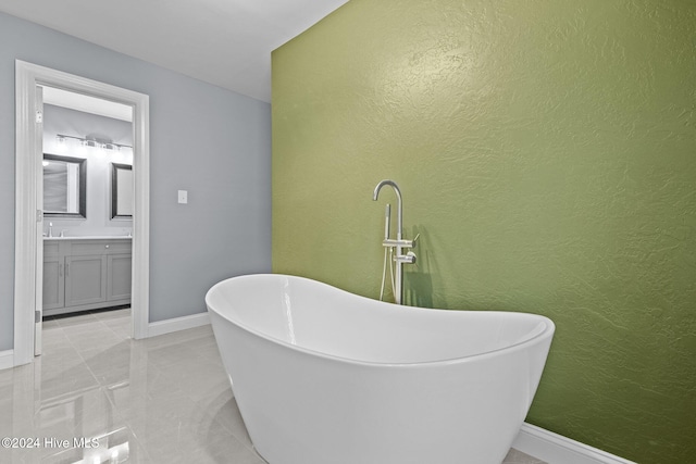 bathroom featuring tile patterned flooring, vanity, and a bath