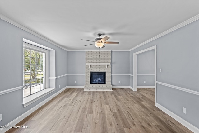 unfurnished living room featuring light hardwood / wood-style floors, a brick fireplace, ceiling fan, and crown molding