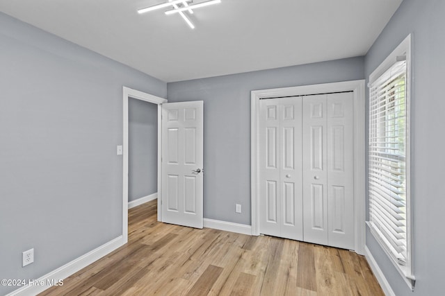 unfurnished bedroom featuring a closet and light hardwood / wood-style flooring