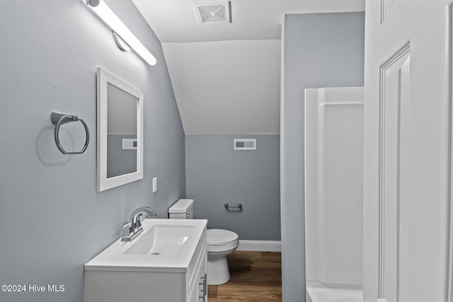 bathroom with walk in shower, lofted ceiling, toilet, vanity, and hardwood / wood-style flooring