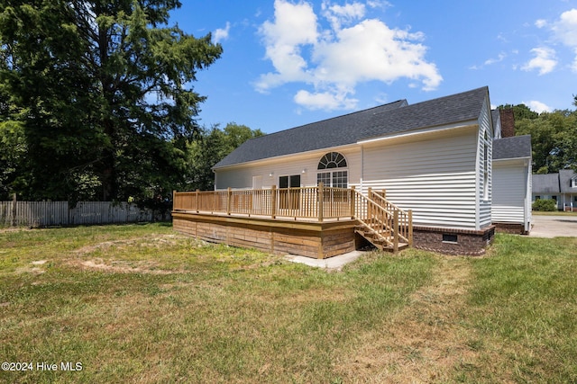 rear view of house featuring a yard and a deck