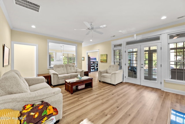 living room with french doors, light hardwood / wood-style flooring, a wealth of natural light, and crown molding