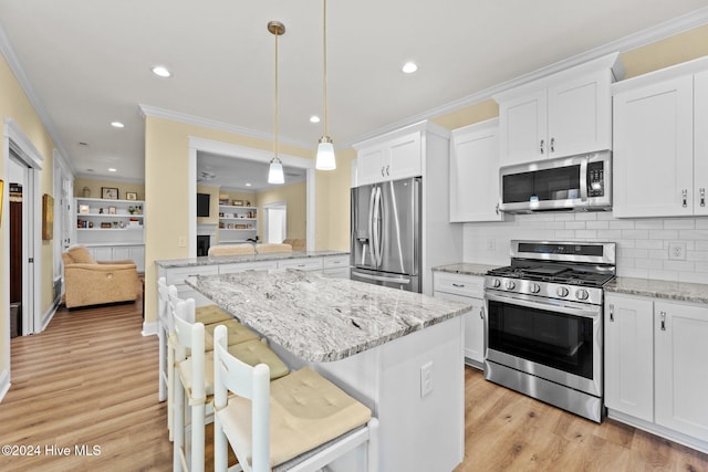 kitchen with a kitchen breakfast bar, light hardwood / wood-style flooring, pendant lighting, white cabinets, and appliances with stainless steel finishes