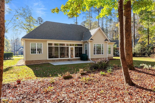 rear view of property featuring a lawn and a patio area