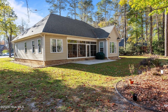 rear view of house with a lawn and a patio