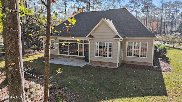 rear view of house with a yard and a patio