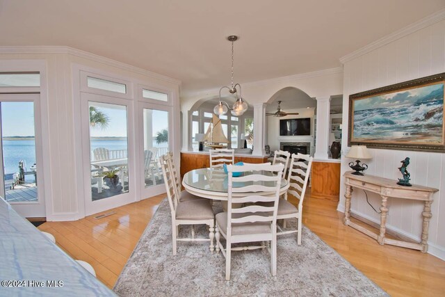 105 Wind Dance Ln, Swansboro, NC 28584 - dining space featuring arched walkways, ornate columns, crown molding, light wood-style floors, and a ceiling fan