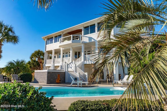 105 Wind Dance Ln, Swansboro, NC 28584 - back of property with a balcony, stairs, a patio, and an outdoor pool