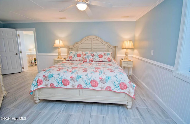 bedroom featuring ceiling fan, crown molding, and light hardwood / wood-style flooring