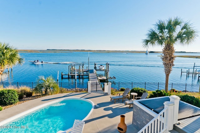 view of pool featuring a patio, a water view, and a dock