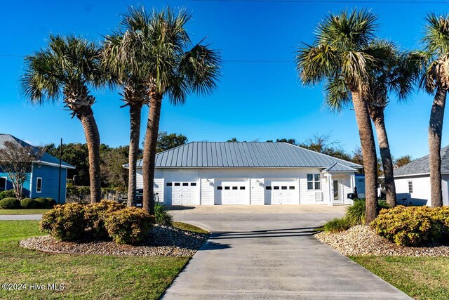105 Wind Dance Ln, Swansboro, NC 28584 - view of front of house featuring a garage, driveway, and metal roof