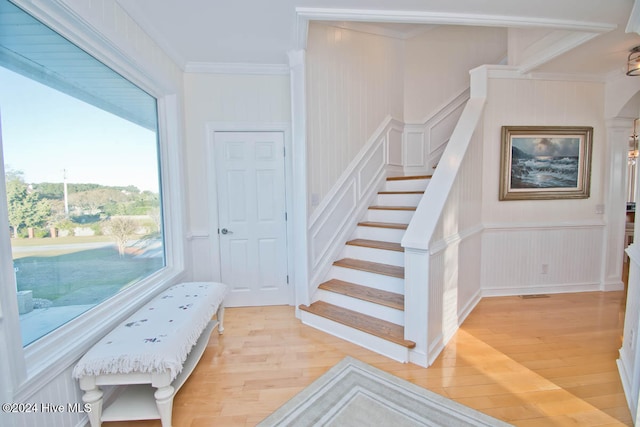 stairs with crown molding and wood-type flooring