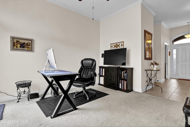 office space featuring light tile patterned floors, light colored carpet, a ceiling fan, baseboards, and ornamental molding