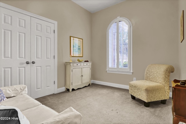 sitting room featuring baseboards and light colored carpet