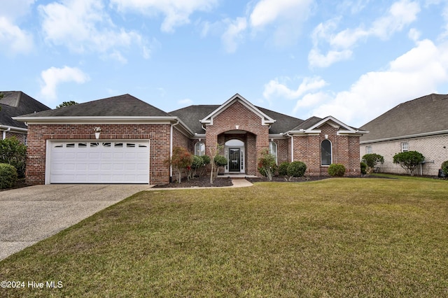 ranch-style home featuring a front yard, concrete driveway, and brick siding