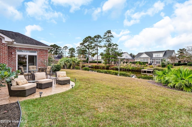 view of yard with a residential view, a patio area, a water view, and an outdoor hangout area