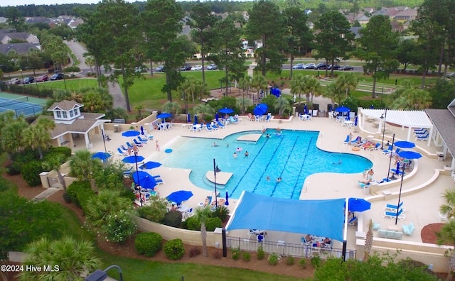 community pool with a patio area and fence