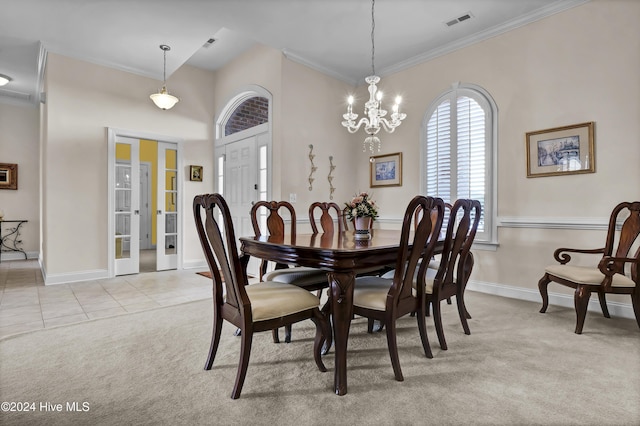 dining area with visible vents, ornamental molding, a notable chandelier, and light colored carpet