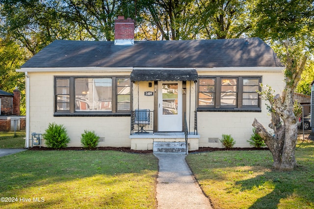 bungalow featuring a front lawn