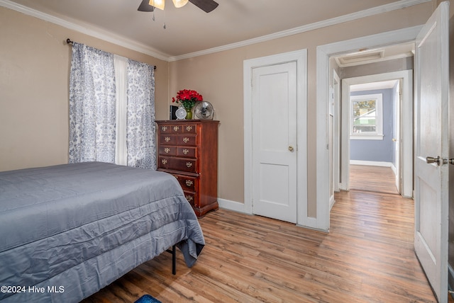 bedroom featuring ceiling fan, crown molding, and wood-type flooring