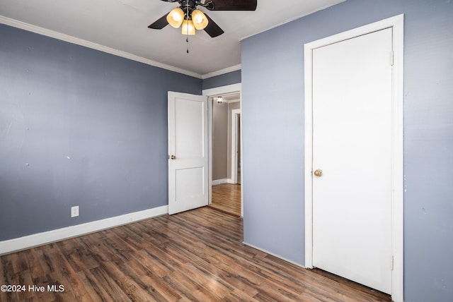 unfurnished bedroom featuring dark hardwood / wood-style floors, ceiling fan, and crown molding