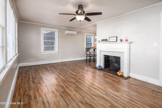 unfurnished living room with ceiling fan, a brick fireplace, a wall unit AC, crown molding, and hardwood / wood-style floors