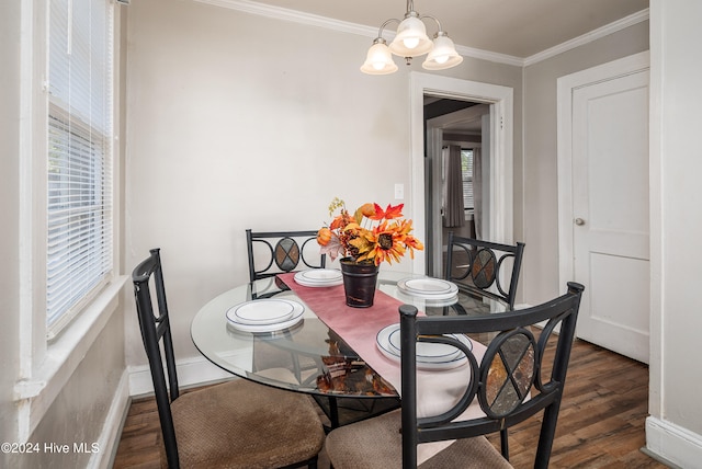 dining space featuring dark hardwood / wood-style flooring, ornamental molding, and a notable chandelier