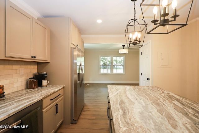 kitchen featuring crown molding, hanging light fixtures, dark hardwood / wood-style floors, light stone counters, and stainless steel fridge with ice dispenser