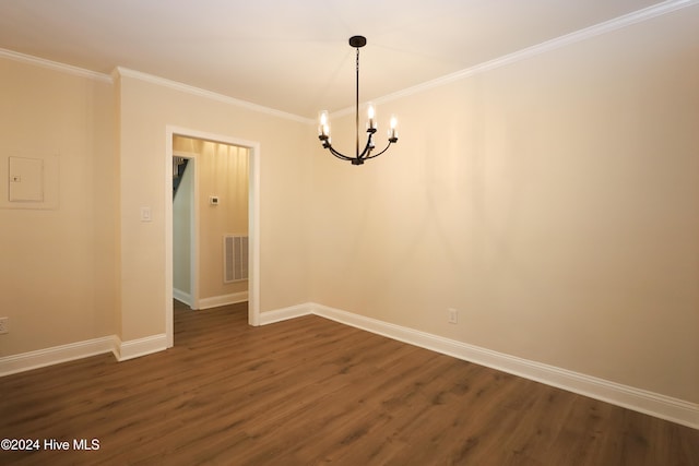 spare room featuring crown molding, dark hardwood / wood-style flooring, and an inviting chandelier