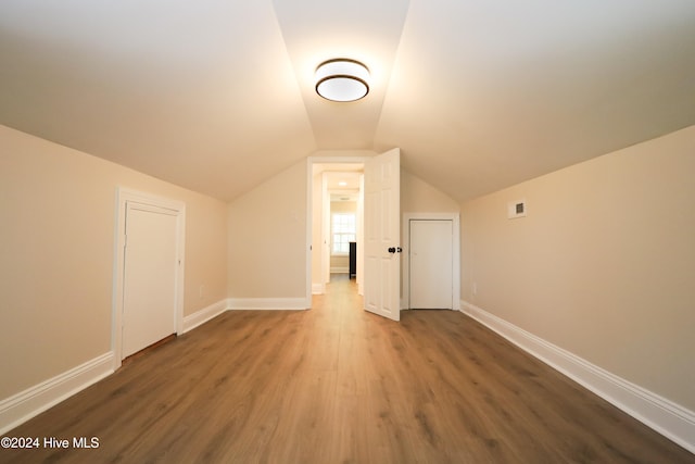 bonus room featuring dark hardwood / wood-style flooring and vaulted ceiling