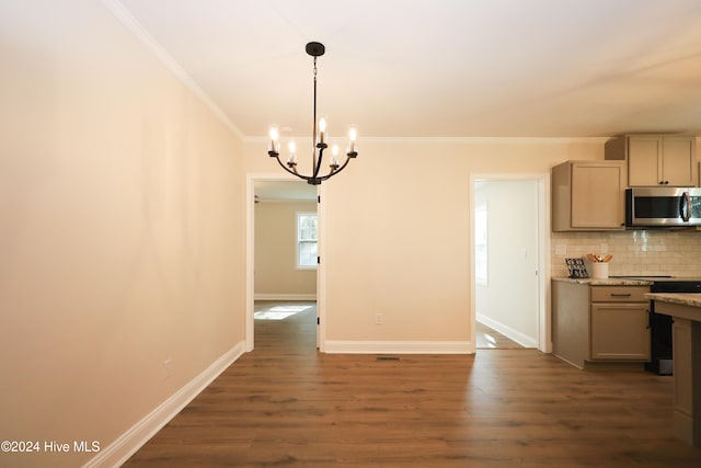 unfurnished dining area featuring ornamental molding, dark wood-type flooring, and a chandelier