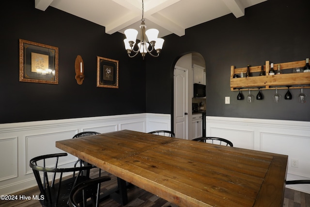 dining room with dark hardwood / wood-style flooring, beamed ceiling, and an inviting chandelier