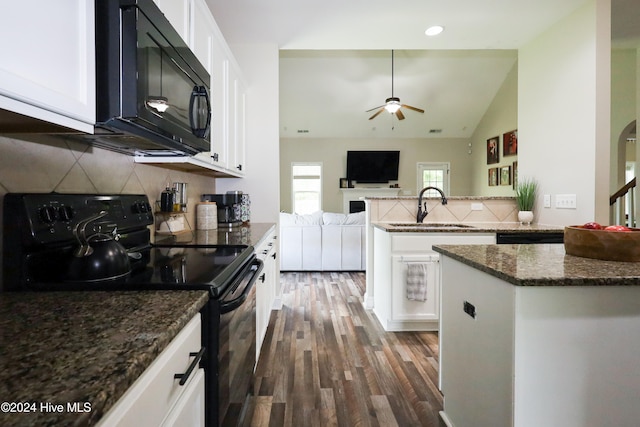 kitchen with sink, dark hardwood / wood-style flooring, vaulted ceiling, white cabinets, and black appliances