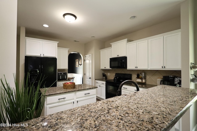 kitchen with white cabinets, decorative backsplash, and black appliances