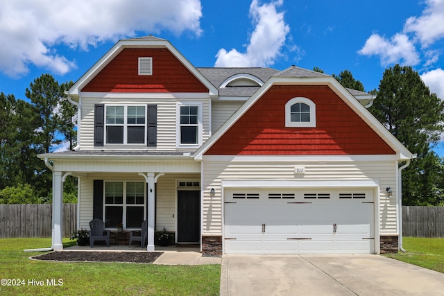 view of front of house with a front yard, a porch, and a garage