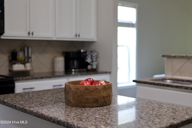 kitchen featuring white cabinetry, plenty of natural light, and light stone counters