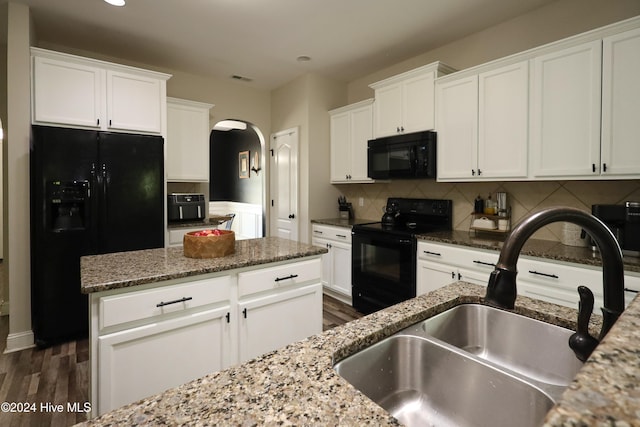 kitchen with dark wood-type flooring, sink, black appliances, stone countertops, and white cabinetry