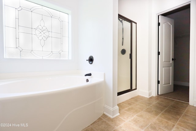 bathroom featuring tile patterned flooring and independent shower and bath