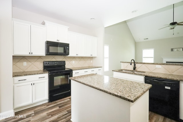 kitchen featuring black appliances, sink, dark hardwood / wood-style floors, a kitchen island, and white cabinetry