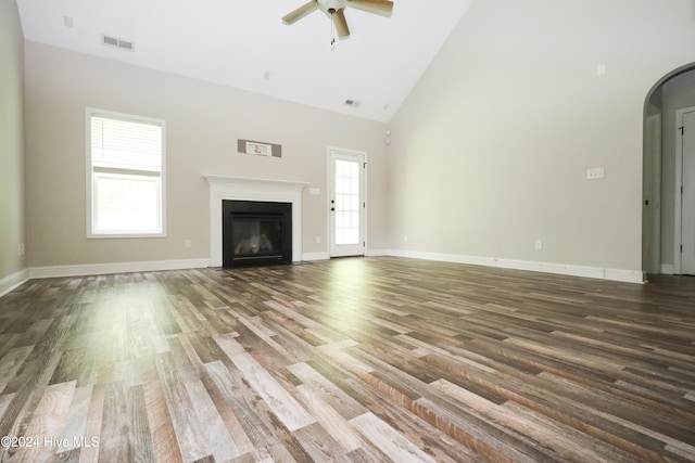 unfurnished living room with ceiling fan, dark hardwood / wood-style flooring, and high vaulted ceiling