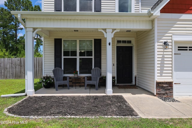 doorway to property featuring a porch and a garage