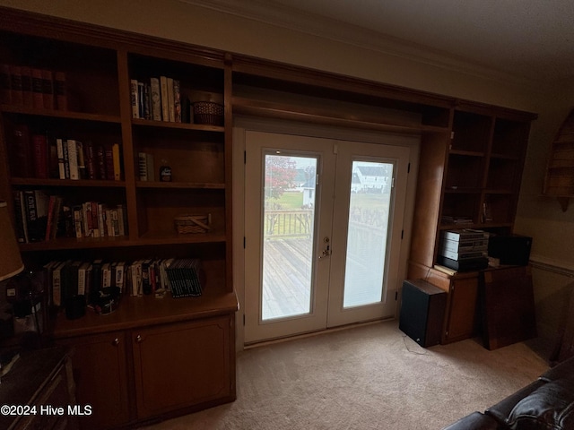 doorway featuring light colored carpet, crown molding, and french doors