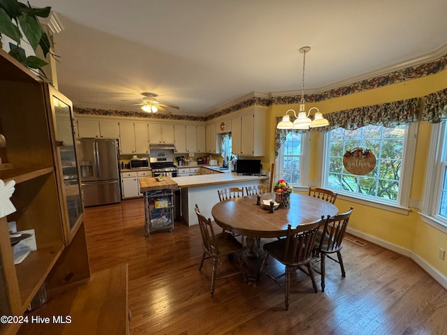 dining area featuring sink, ceiling fan with notable chandelier, dark hardwood / wood-style floors, and ornamental molding