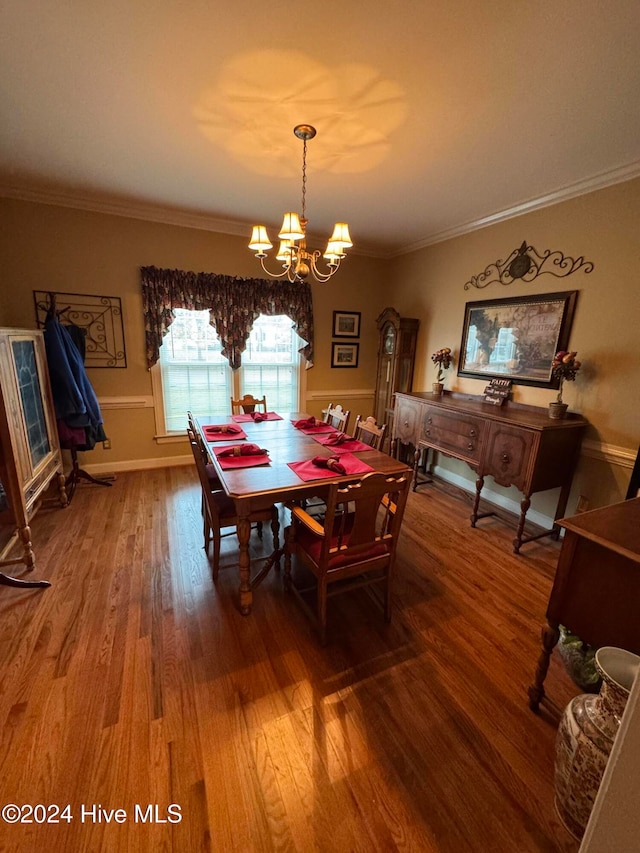 dining room featuring crown molding, wood-type flooring, and an inviting chandelier