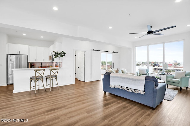 living room with ceiling fan and wood-type flooring